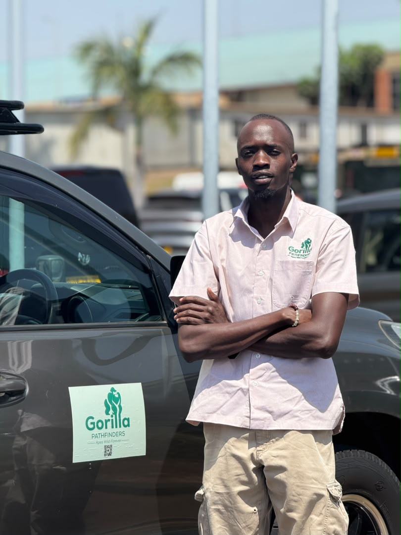 Gorilla Pathfinders safari guide standing beside a branded four-wheel-drive vehicle