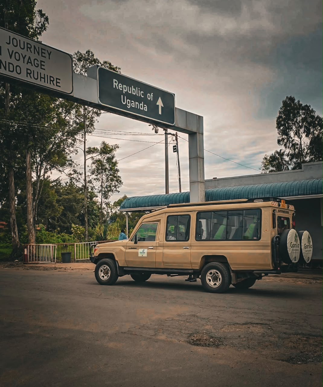 Gorilla Pathfinders tourist vehicle beneath the Republic of Uganda sign at a border crossing